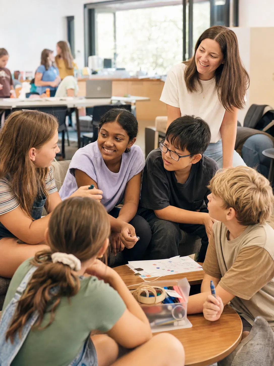 A OneHope leader and primary school children talking together during an activity