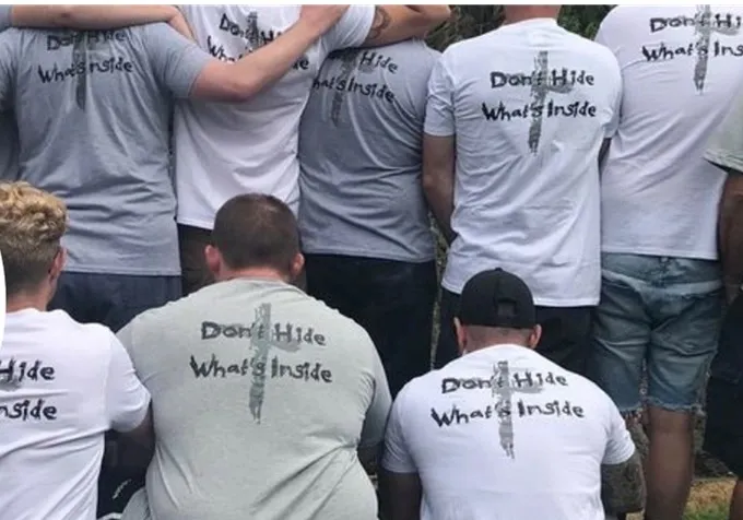 Men in Foundation 61's community standing arm in arm in support
